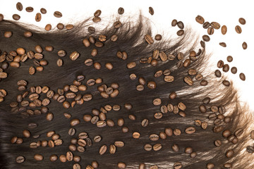 Dark hair isolated on white background sprinkled with coffee beans