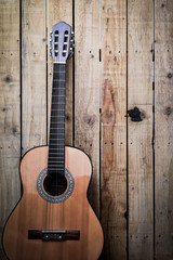 Acoustic guitar on vintage style wood background. Copy space with musical guitar instrument