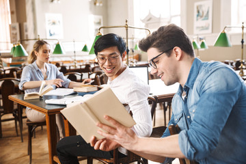 Smart cheerful teenagers studying at the library together