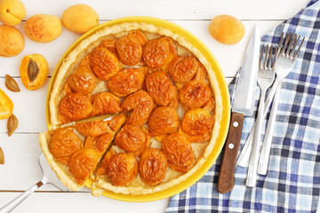 Homemade apricot pie with fresh fruits on white wooden table. Top view.