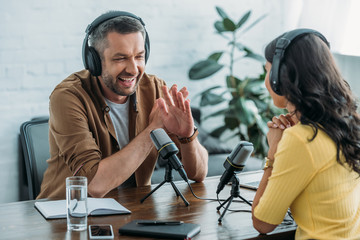cheerful radio host showing no sign while recording podcast with colleague - obrazy, fototapety, plakaty