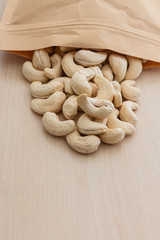 Cashew nuts and packaging bag on a floor wooden ,closeup