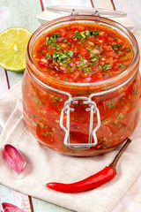 Tomato salsa in a glass jar.