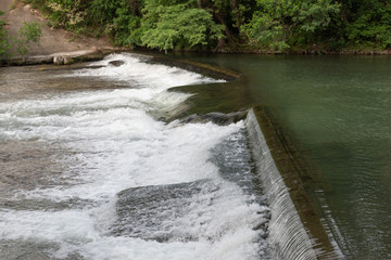 Waterfall in river going to bridge