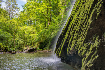 Beautiful waterfall falling from a rock covered by moss. Kot waterfall, San Leonardo village close...