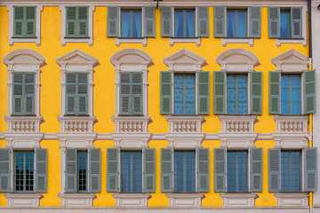 Fototapeta na wymiar Nice in France, colorful facade, with typical murals windows and green shutters, place Garibaldi, detail 