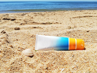 Sun cream boat on the beach sand.