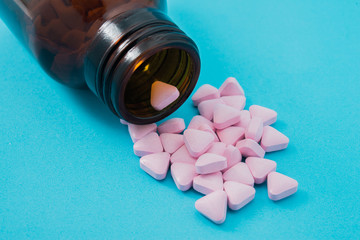 Medical pills spilling out of a toppled from pill bottle