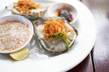 Fresh Oyster Thai style with spicy sauce serve with Chili paste, crispy shallots, garlic and fresh vegetable.
