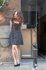 Young woman in dress posing in front of the camera.