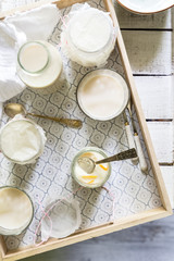 Top view of vegan panna cotta dessert and almond milk on a breakfast tray on white wooden rustic background