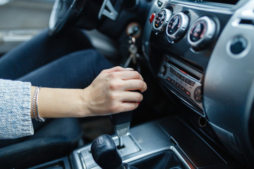 Woman switches the automatic transmission's close-up. Close-up of the driver's adm includes mode Drive on the gear lever automatic transmission of the car interior parts