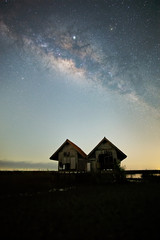 Milky Way , old abandoned house, red roof on open field