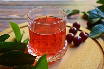 Delicious and healthy cherry drink and fresh berry on wooden background.