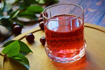 Delicious and healthy cherry drink and fresh berry on wooden background.