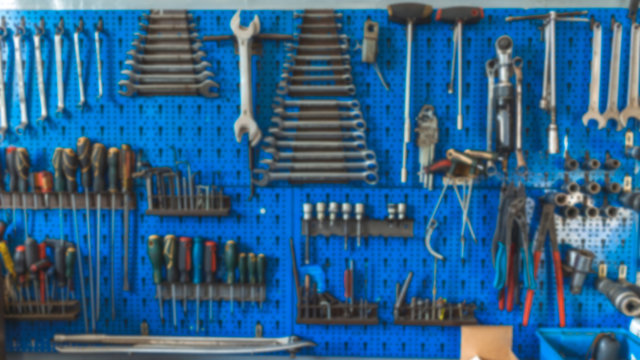 Wrenches set in the workshop. Some wrenchs and tools on the tool shelf. Work tools on the garage wall and work table. Workshop tool holder with a wrench and set of wrench sockets © Dragana Gordic