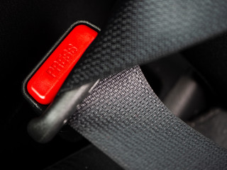Close up of the word press on a button of a Seat belt on black car seat