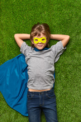 Confident superhero lying on lawn