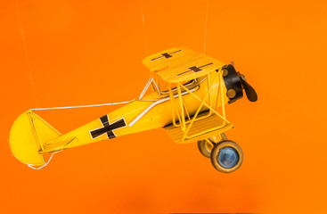 yellow color metal air plane toy display on orange background