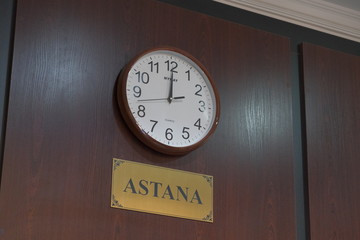 round clock hanging on the wall showing time in the city of Astana