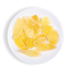 Ginger candied fruit, dried ginger with sugar in plate on a white background, top view on a white...