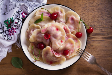 Dumplings, filled with cherries. Varenyky, vareniki, pierogi, pyrohy - dumplings with filling. View from above, top studio shot