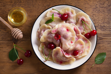 Dumplings, filled with cherries. Varenyky, vareniki, pierogi, pyrohy - dumplings with filling. View from above, top studio shot
