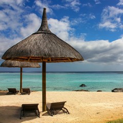 Two lounge chairs with sun umbrella on a beach