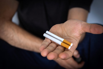 Man holding a cigarette, closeup cigarette and hand. Bad habits.