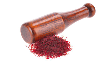 heap of saffron and wooden pestle isolated on white background