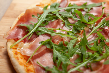 Close up of Pizza with prosciutto (parma ham) and  arugula (salad rocket)