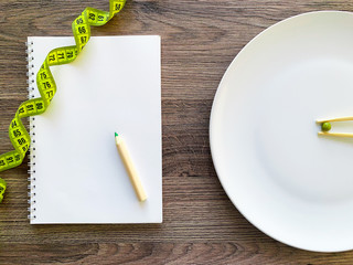 Cropped image pea on white plate, with fork and measuring