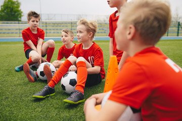 Happy kids in school sports team. Boys gathering and having fun on sports field. Cheerful children...
