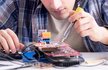 Obraz na płótnie Canvas Professional repairman repairing computer in workshop