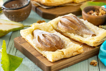 Summer dessert. Homemade Cake Puff Pastry with Pear and Stuffed with Nut Cream a rustic wooden table.