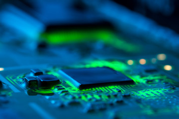 Electronic circuit board close up with green backlight and a light haze