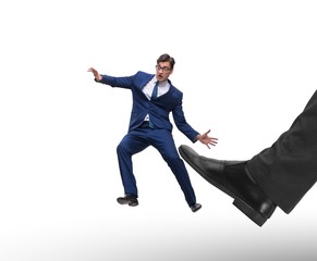 Bad angry boss kicking employee in business concept