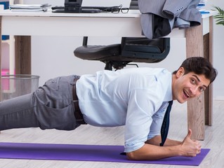 Businessman doing sports in office during break