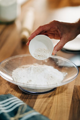 making homemade pizza dough on wooden countertop with wholemeal flour