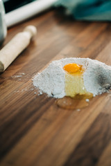 making homemade pizza dough on wooden countertop with wholemeal flour