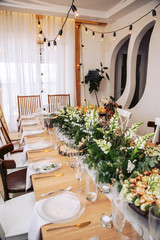 The table in the interior is decorated with natural wood elements and fresh bouquets of greenery.