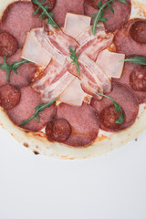 Pizza with salami, bacon and ham on white background