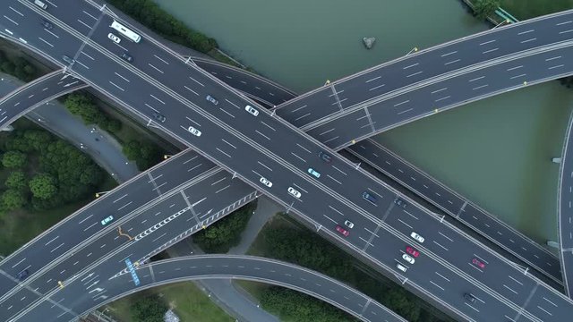 Aerial drone view of highway multi-level junction road with moving cars at sunset. Cars are moving on a multi-level road junction The concept of the urban. Suzhou city, China.