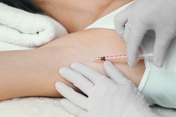 Obraz na płótnie Canvas woman receives an underarm treatment, hyperhidrosis. Armpit injections to prevent excessive sweating
