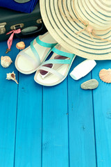 a holiday photo a summet hat, beach sandals,sunscreen,sun glasses, scallops and souvenir pebbles. Empty space for an inscription