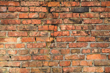 Old brick wall weathered and broken bricks, background