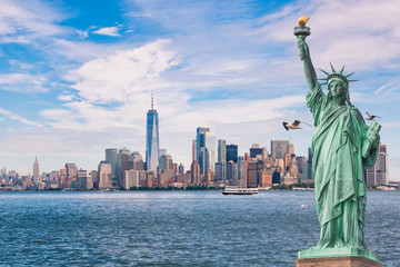 Freiheitsstatue vor der Skyline von Manhattan, in New York City, USA, mit Möwen und Booten