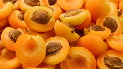Ripe juicy orange apricots slices fruit background.