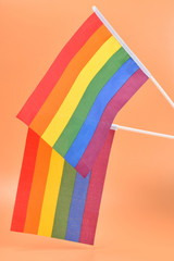 LGBT flag on orange background. Copy space.