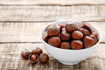 Hazelnuts in bowl on wooden table